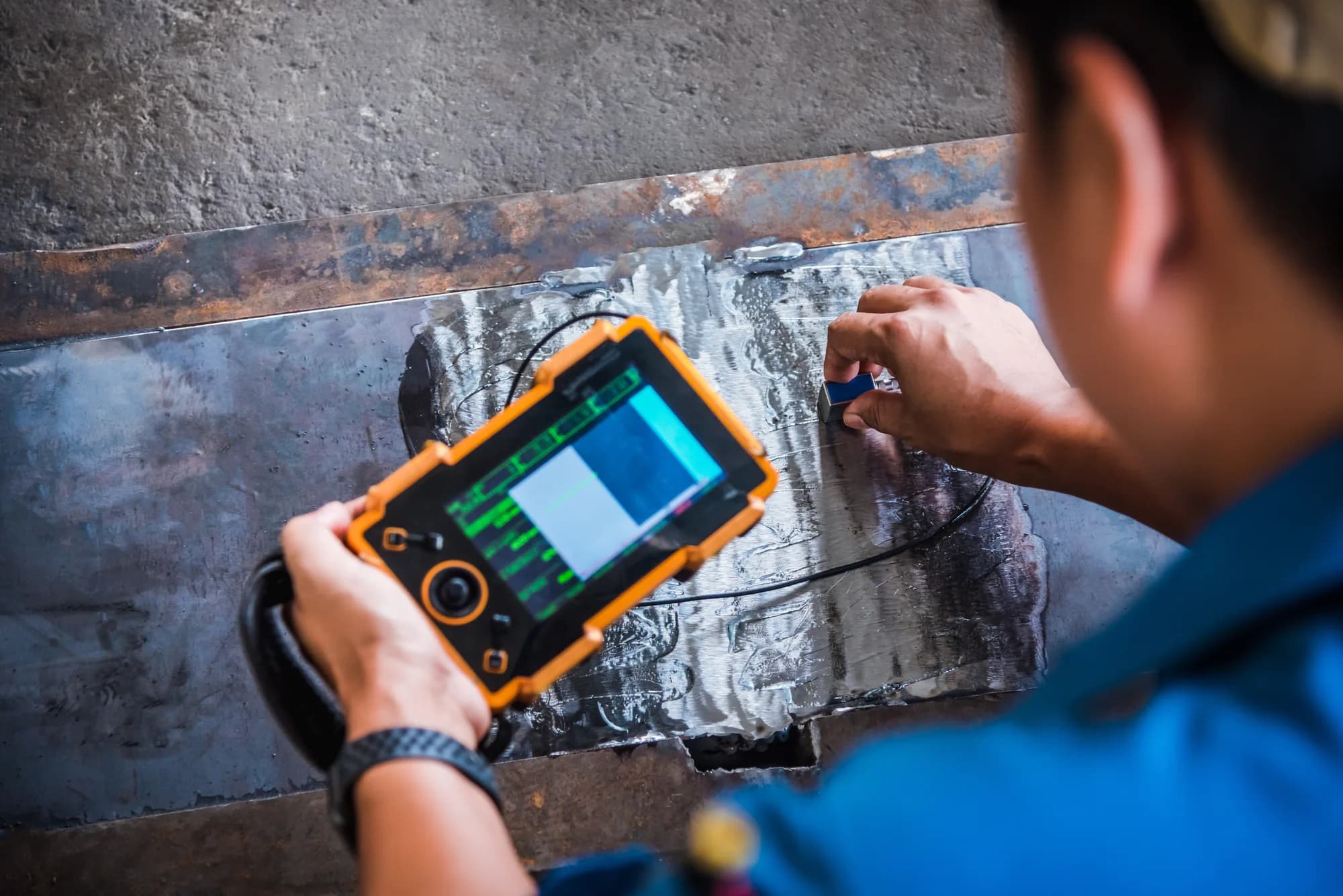 Inspector witnessing ultrasonic testing on industrial equipment during factory acceptance testing