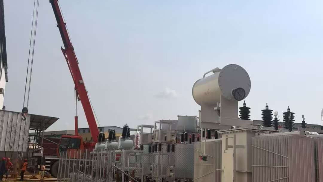 Power transformer being positioned by crane at a substation commissioning site