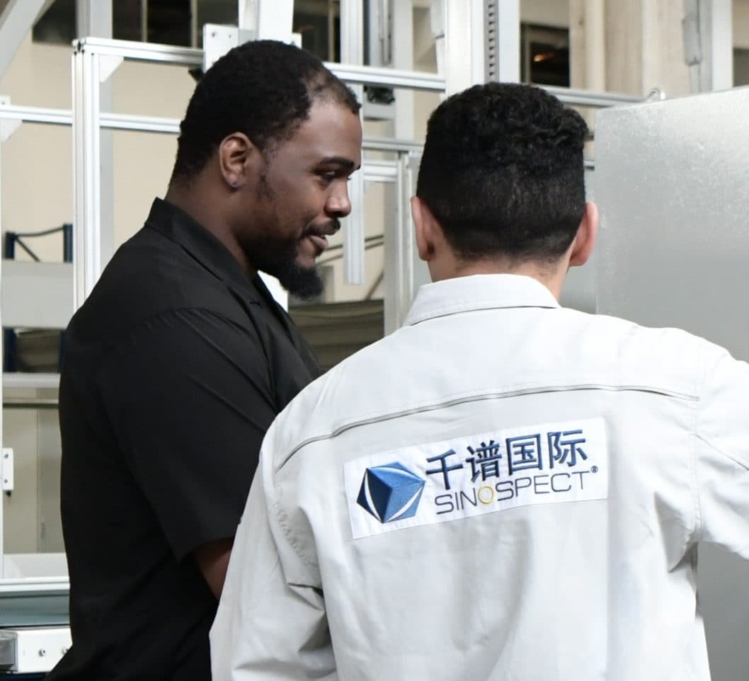 Client-side witness check on the supplier floor in China — two inspectors reviewing equipment on site.